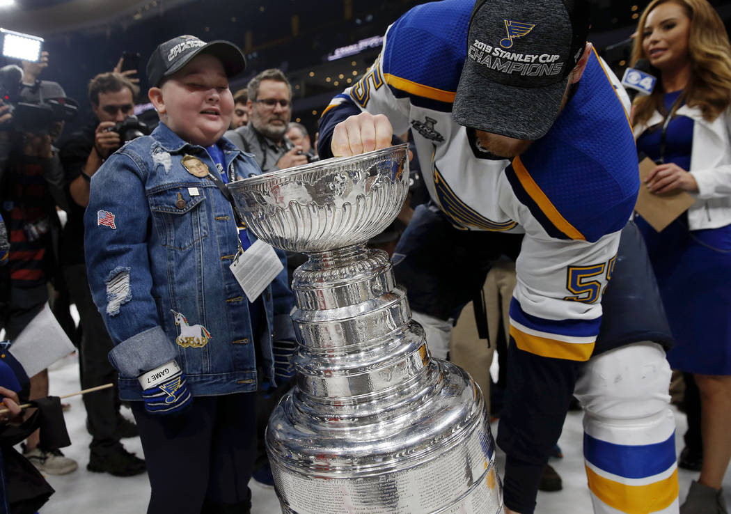 St. Louis Blues fan Laila Anderson, left, watches Colton Parayko lift the Stanley Cup while the ...