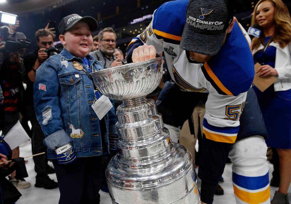 St. Louis Blues fan Laila Anderson, left, watches Colton Parayko lift the Stanley Cup while the ...