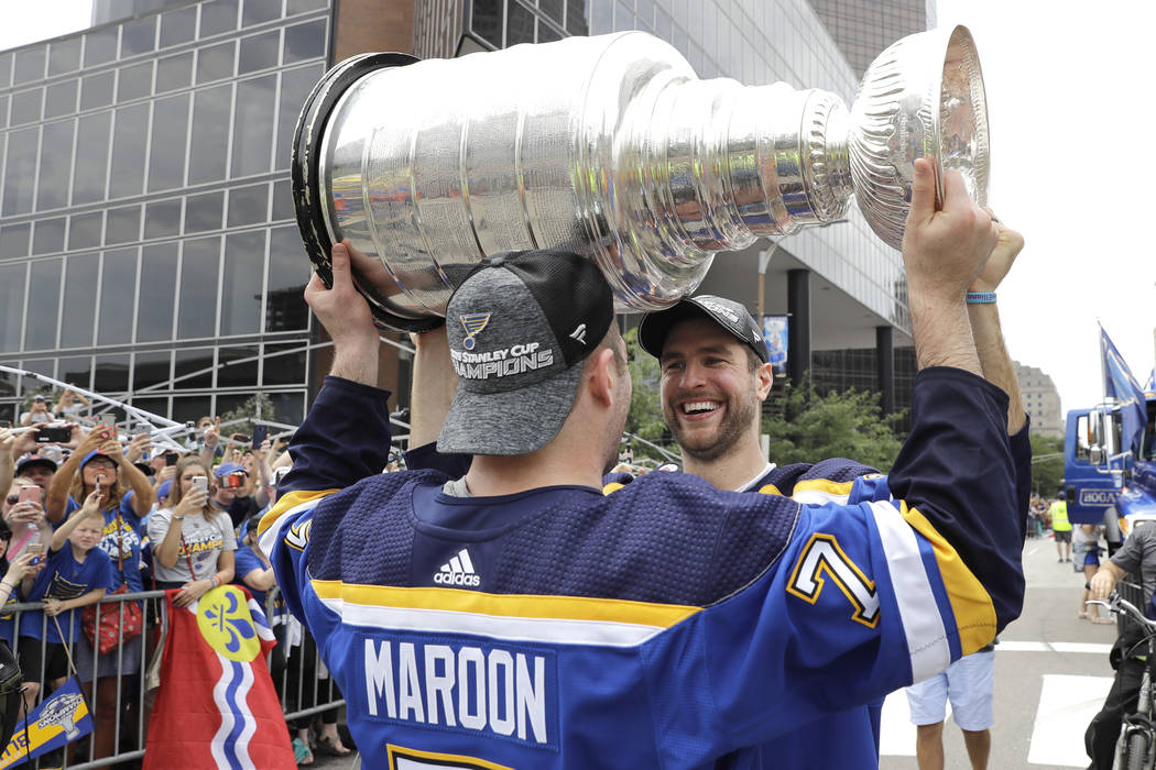 St. Louis Blues defenseman and captain Alex Pietrangelo, right, hands the Stanley Cup to left w ...