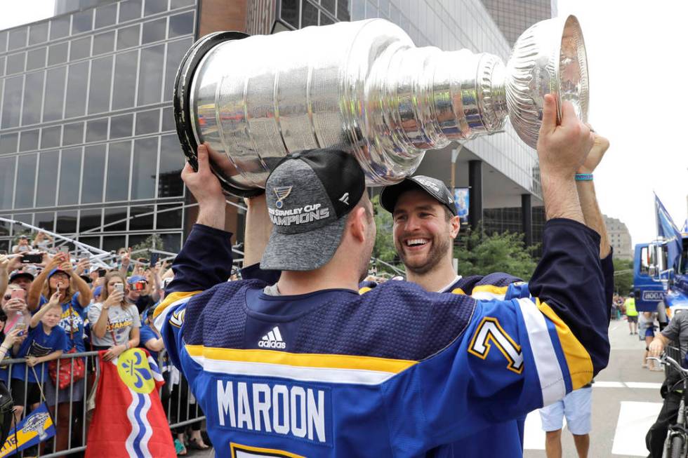 St. Louis Blues defenseman and captain Alex Pietrangelo, right, hands the Stanley Cup to left w ...