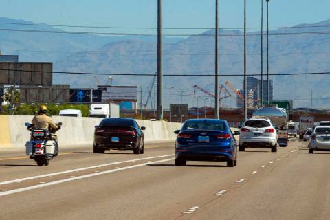 A Las Vegas Metropolitan motorcycle officer trails a vehicle in the HOV lane northbound on Inte ...