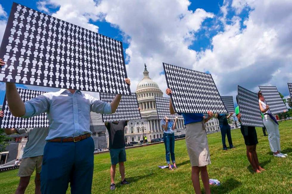 Gun violence prevention advocates hold posters to represent the estimated 11,400 people who hav ...