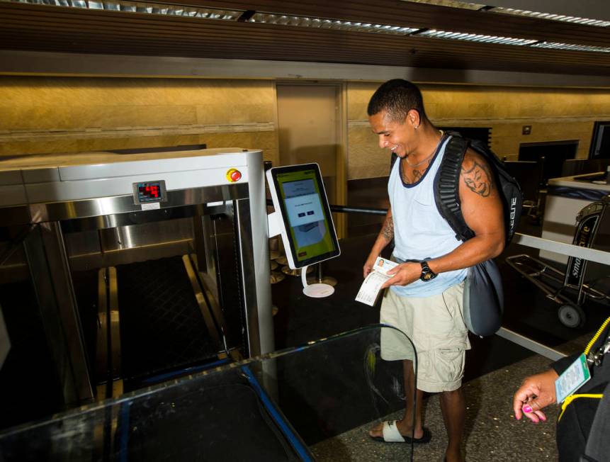 Jerrel Oneal of Beaverton, Oregon, uses the Spirit Airlines automated self-service bag drop sys ...