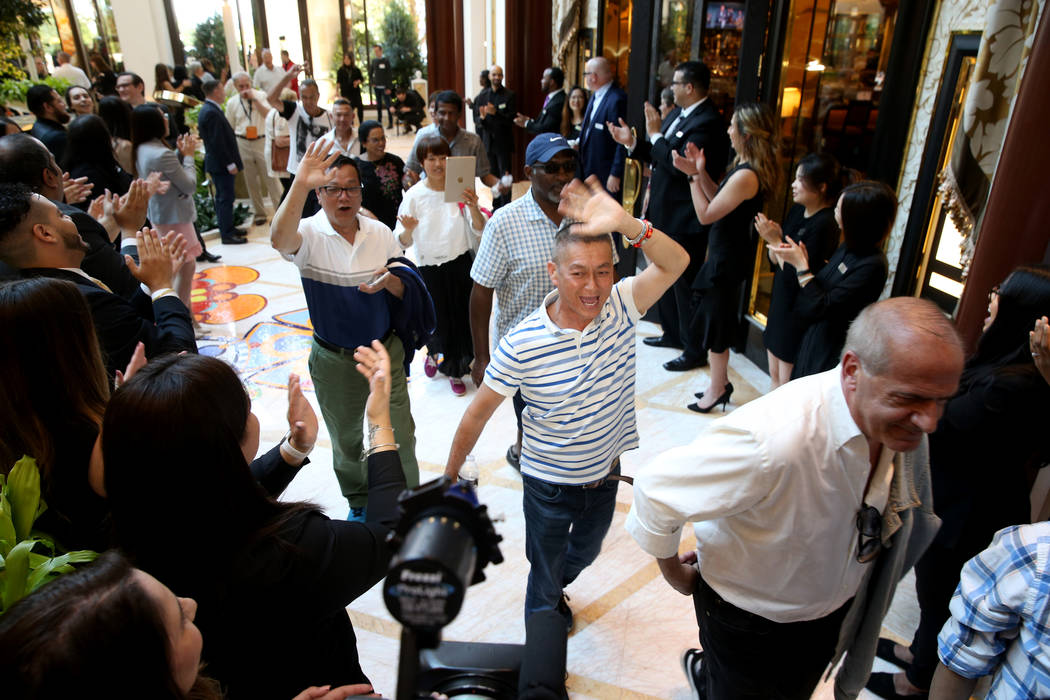 Employees cheer as some of the first guests arrive in the Garden Lobby during the opening of th ...