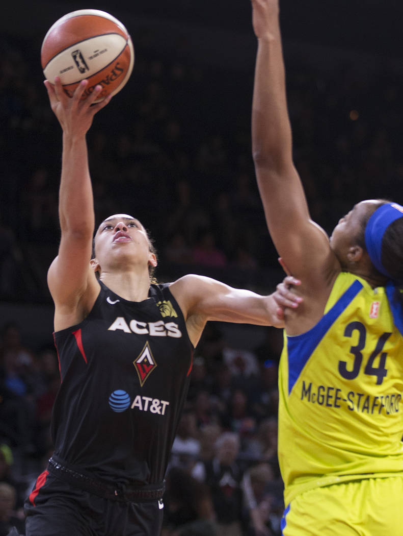 Las Vegas Aces forward Dearica Hamby (5) slices to the rim past Dallas Wings center Imani McGee ...