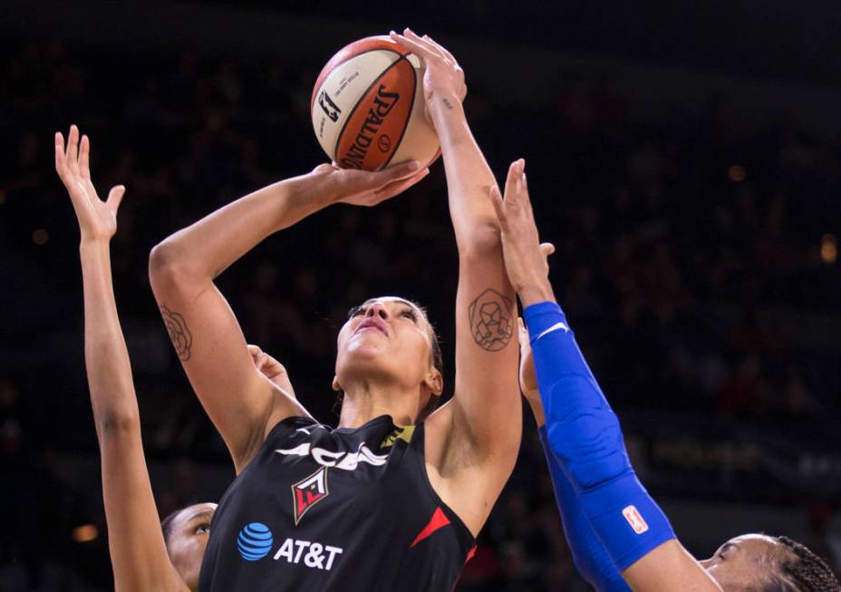 Las Vegas Aces center Liz Cambage (8) splits two Dallas Wings defenders in the first quarter du ...