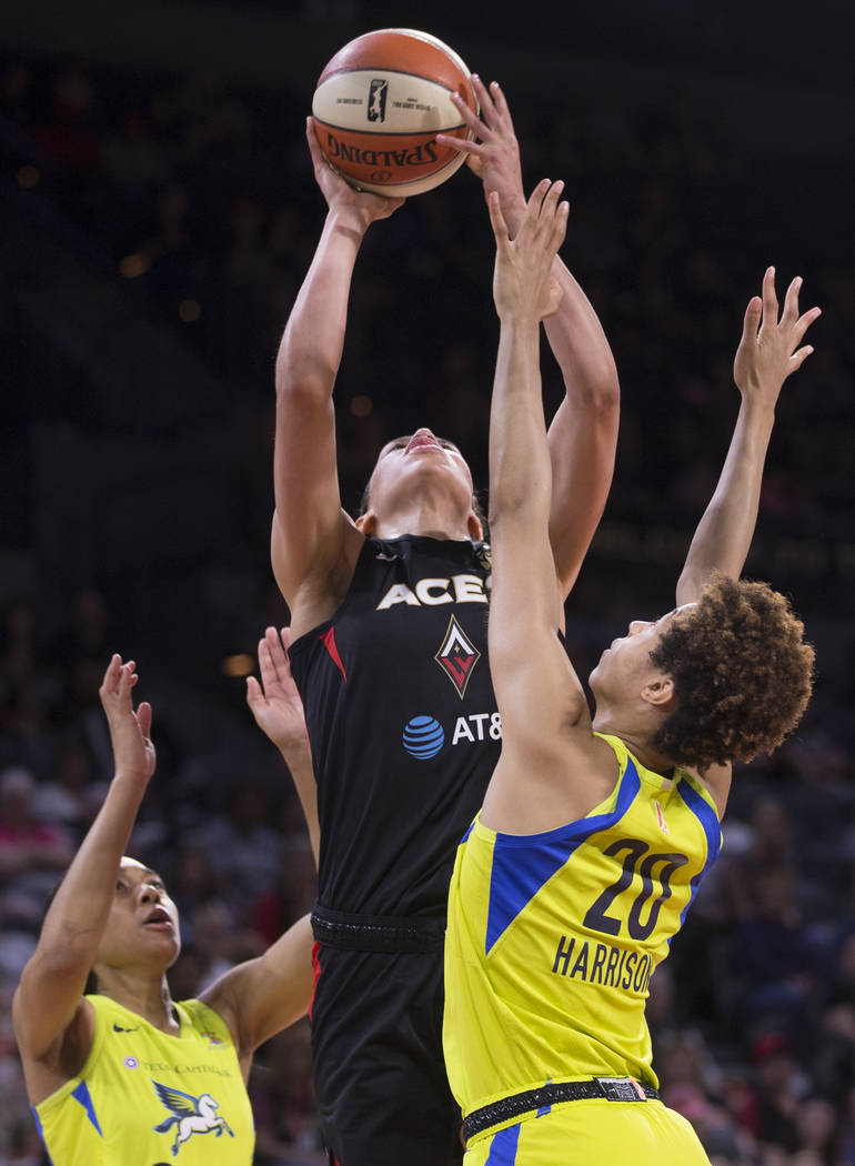 Las Vegas Aces forward Dearica Hamby (5) grabs a rebound over Dallas Wings forward Isabelle Har ...