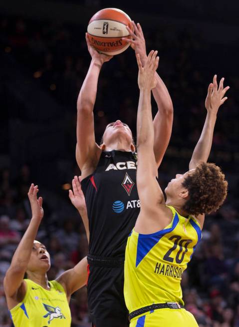 Las Vegas Aces forward Dearica Hamby (5) grabs a rebound over Dallas Wings forward Isabelle Har ...