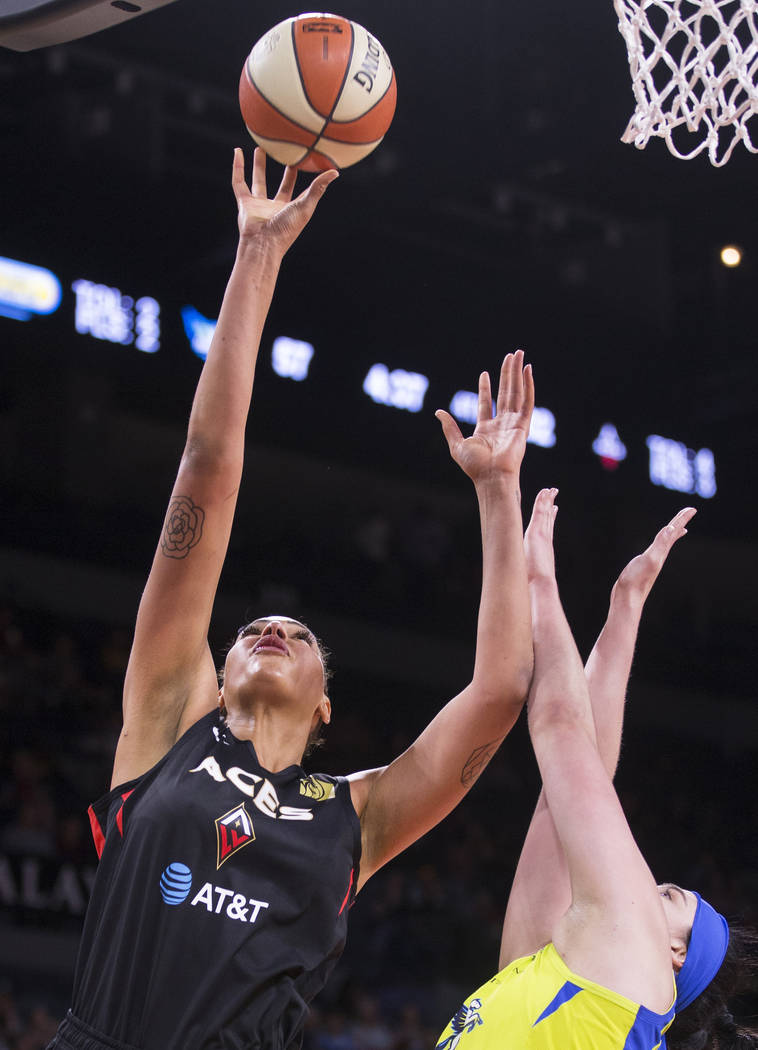 Las Vegas Aces center Liz Cambage (8) drives past Dallas Wings forward Megan Gustafson (13) in ...