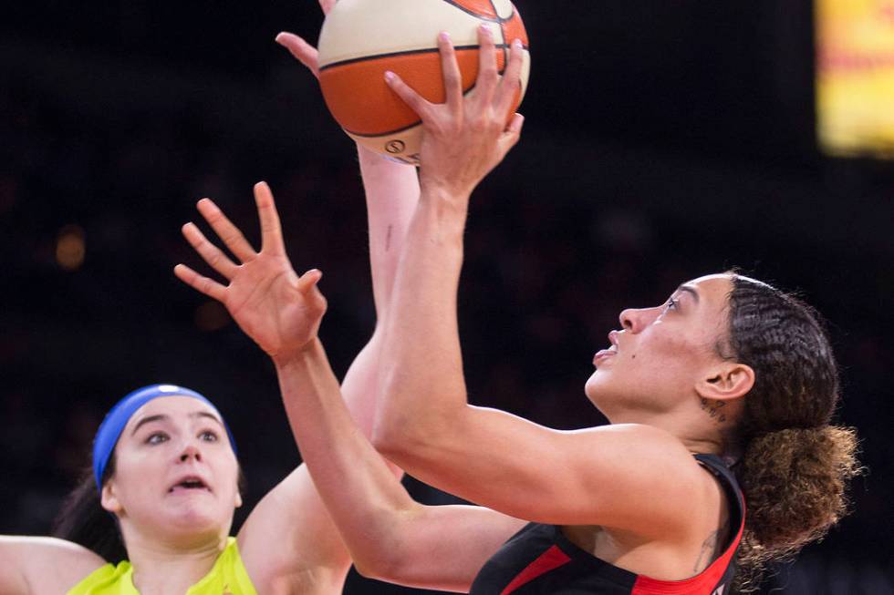 Las Vegas Aces forward Dearica Hamby (5) drives past Dallas Wings forward Megan Gustafson (13) ...