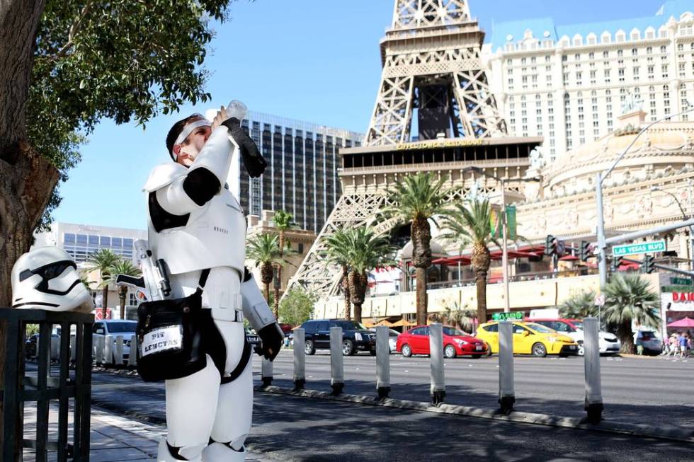 Street performer Adam Reynolds stays hydrated as he works in the hot weather near the Bellagio ...