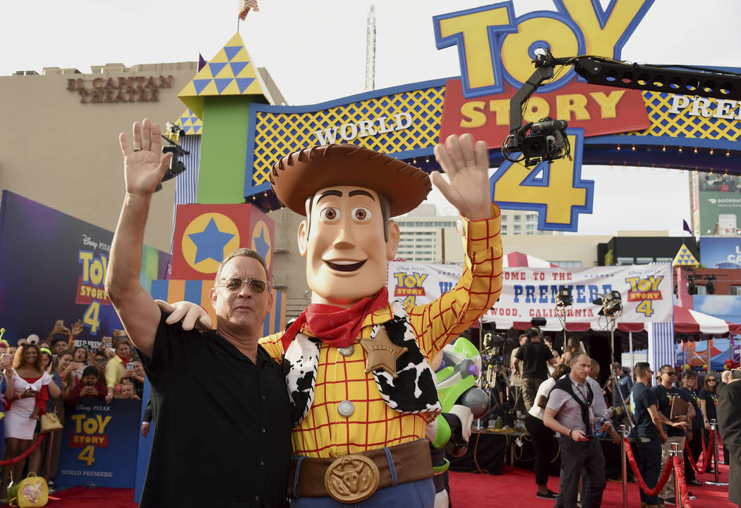 Tom Hanks, left, poses with his character Woody as he arrives at the world premiere of "To ...