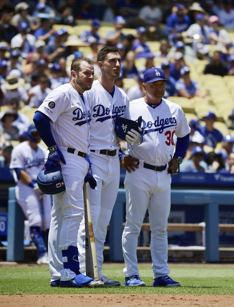 Los Angeles Dodgers Max Muncy, left, stand with Cody Bellinger, center, and manager Dave Robert ...