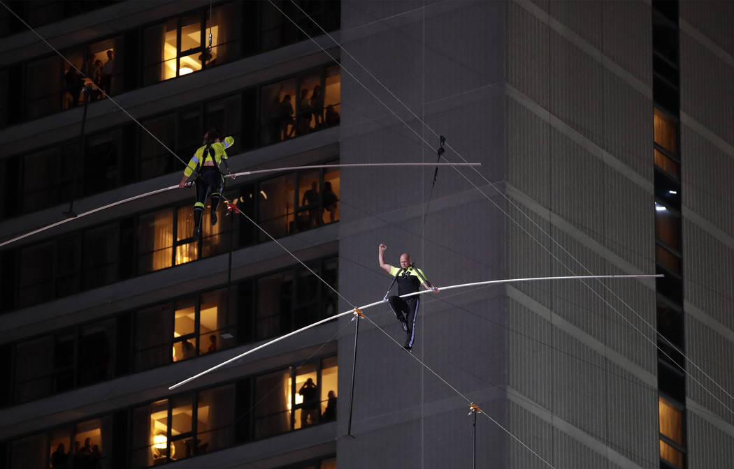 Aerialists Nik Wallenda, right, and his sister Lijana walk on a high wire above Times Square, S ...