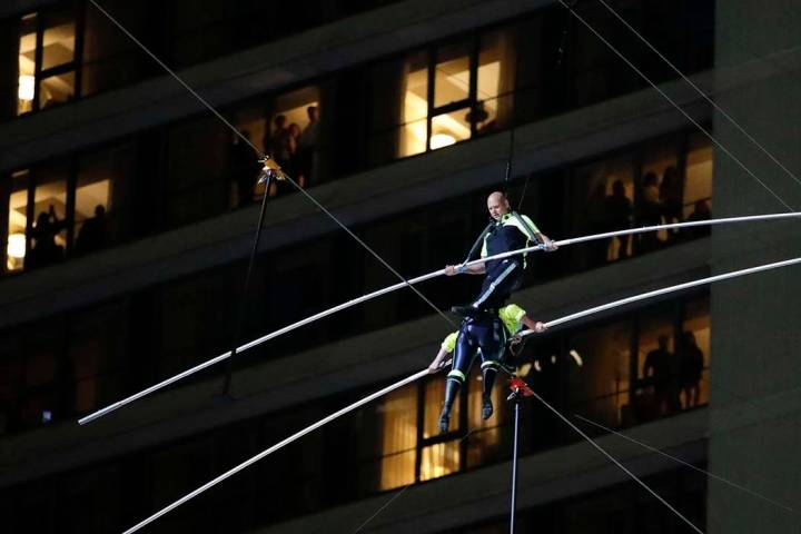 Aerialists Nik Wallenda, top, steps over his sister Lijana as they walk on a high wire above Ti ...