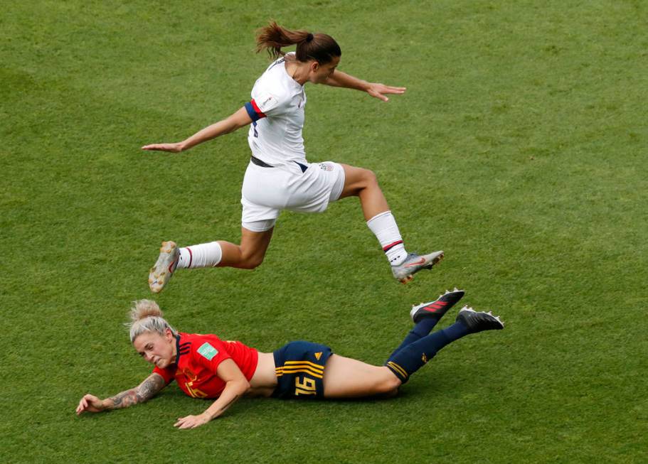 United States' Tobin Heath, top, jumps over Spain's Maria Leon during the Women's World Cup rou ...