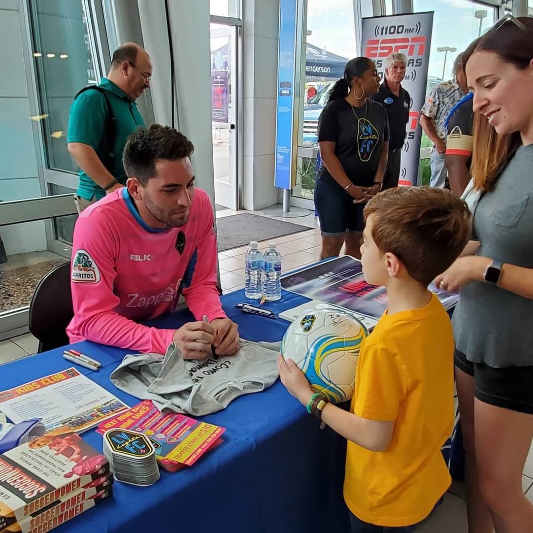 Las Vegas Lights goalie Thomas K. Olsen signs a soccer ball for unidentified young soccer playe ...