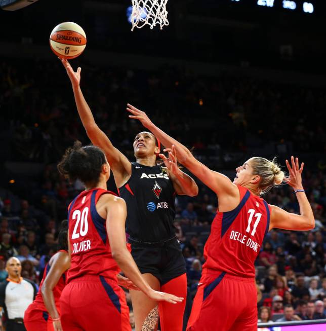 Las Vegas Aces center A'ja Wilson (22) goes to the basket between Washington Mystics guard Kris ...