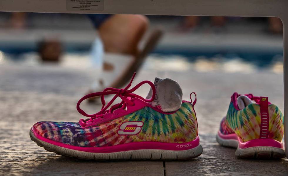 Rainbow sneakers are left under a lounge chair in the pool area during Pride Night at the Las V ...