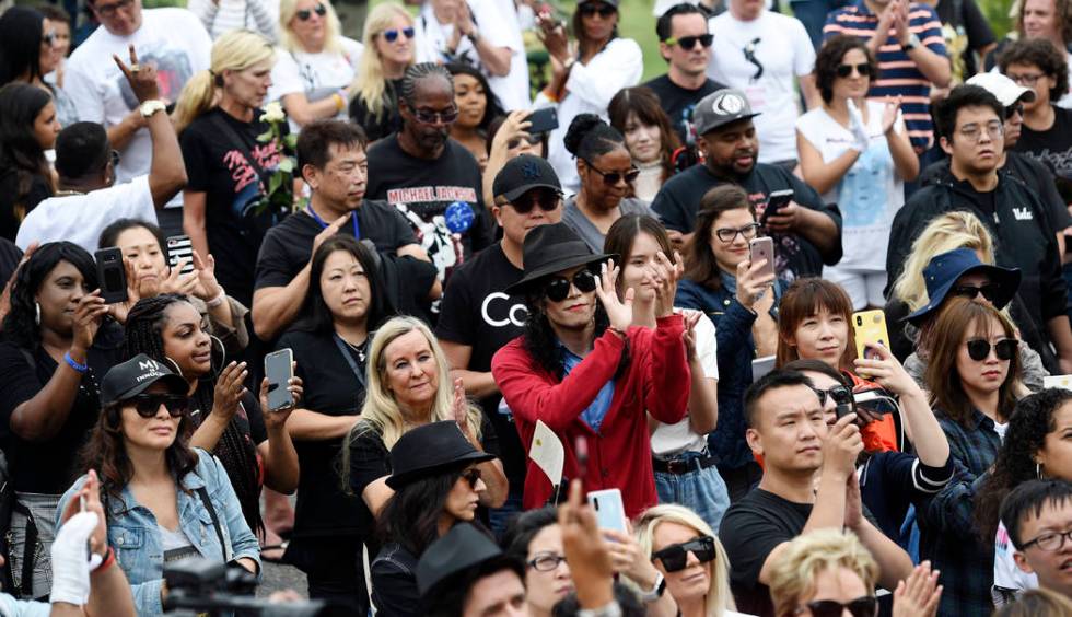 Fans of Michael Jackson including Jackson impersonator Rem Garza, center, stand outside the lat ...