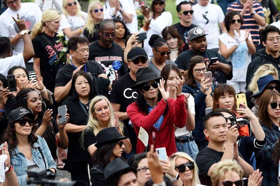 Fans of Michael Jackson including Jackson impersonator Rem Garza, center, stand outside the lat ...