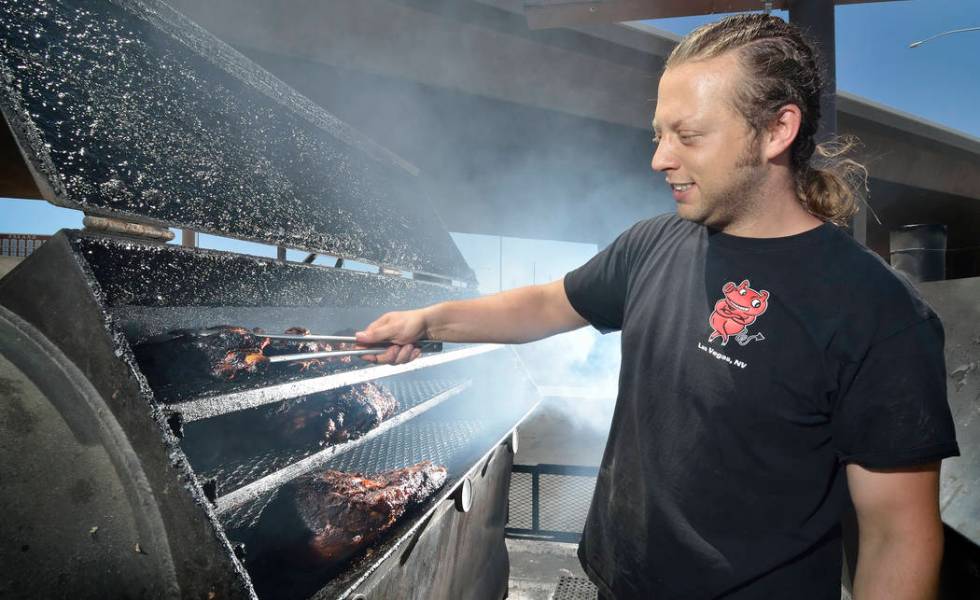 Pit master Dusty Ardoin checks on one of the smokers at Rollin' Smoke Barbeque at 3185 Highland ...