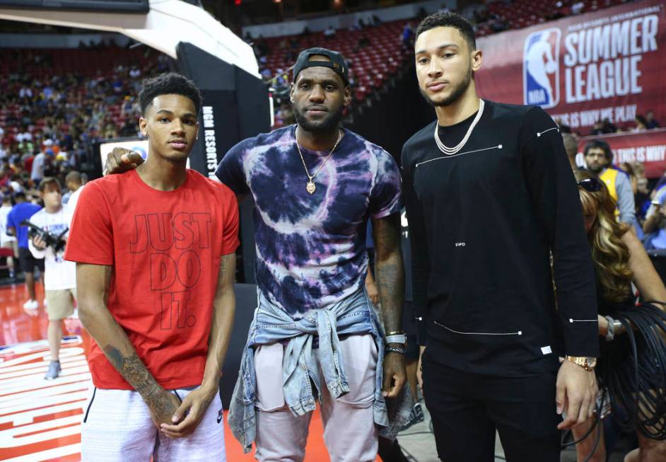 LeBron James, center, poses with Dejounte Murray, left, and Ben Simmons at halftime as the Los ...