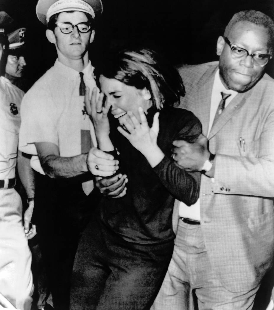 In this Aug. 21,1964 file photo an overwrought Beatles fan is escorted from the hall during the ...