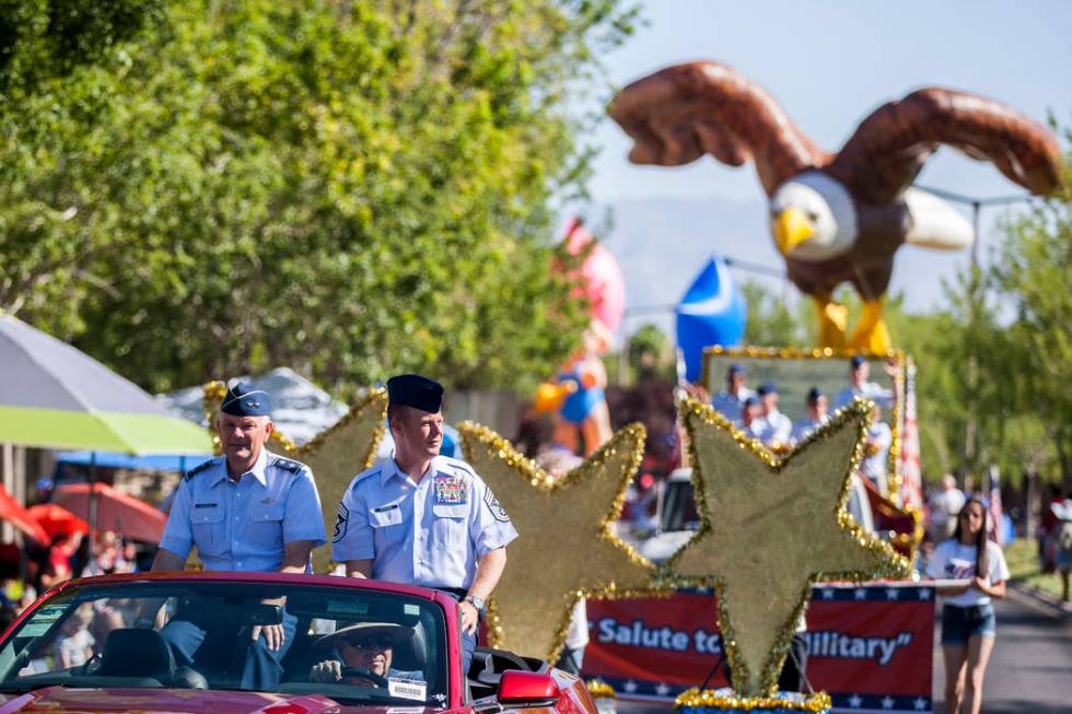 Servicemen drive by with an eagle float in the background during the Summerlin Council Patrioti ...