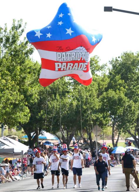 Participants walk with a patriotic star balloon to start the Summerlin Council Patriotic Parade ...