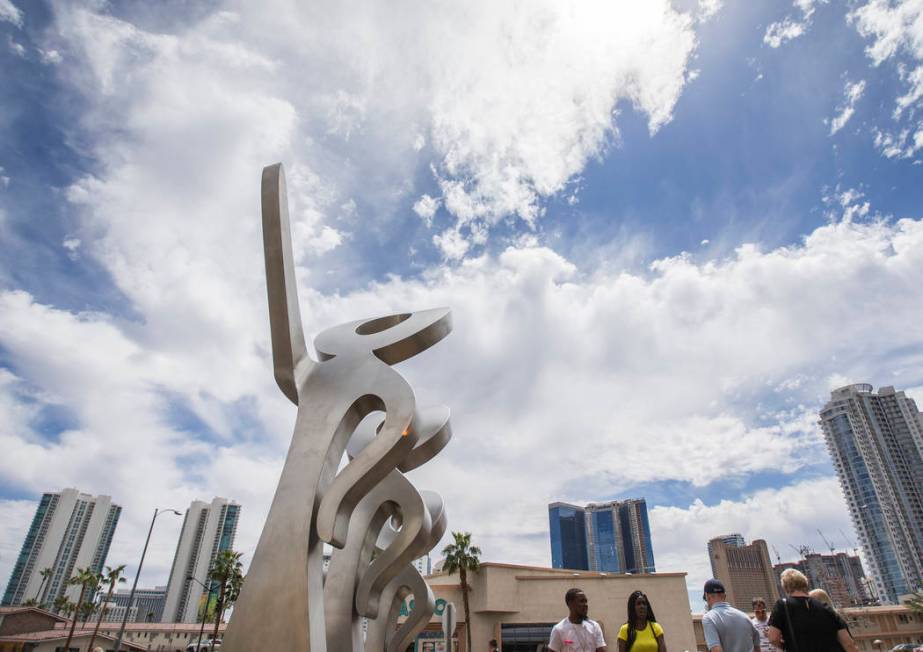 People walk by a new statue called "LOOK!" outside The Strat on Friday, April 19, 201 ...