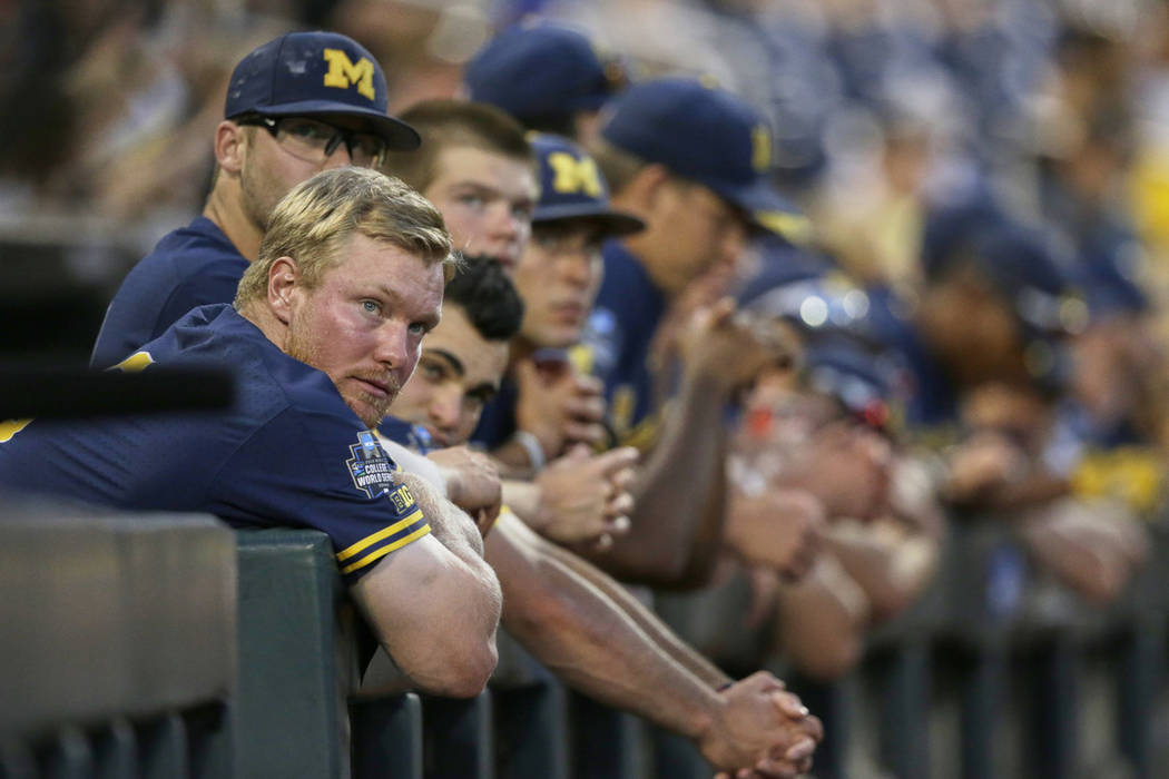 Michigan players including Miles Lewis, left, follow the ninth inning of Game 3 of the NCAA Col ...