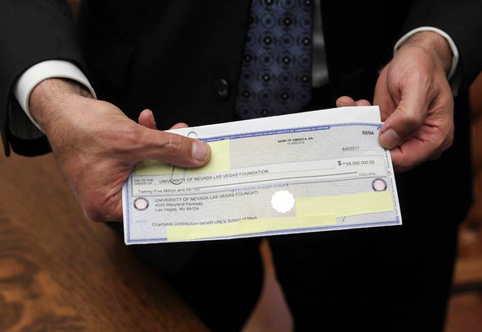 Gov. Brian Sandoval shows the $25 million check from an anonymous donor for the UNLV medical sc ...