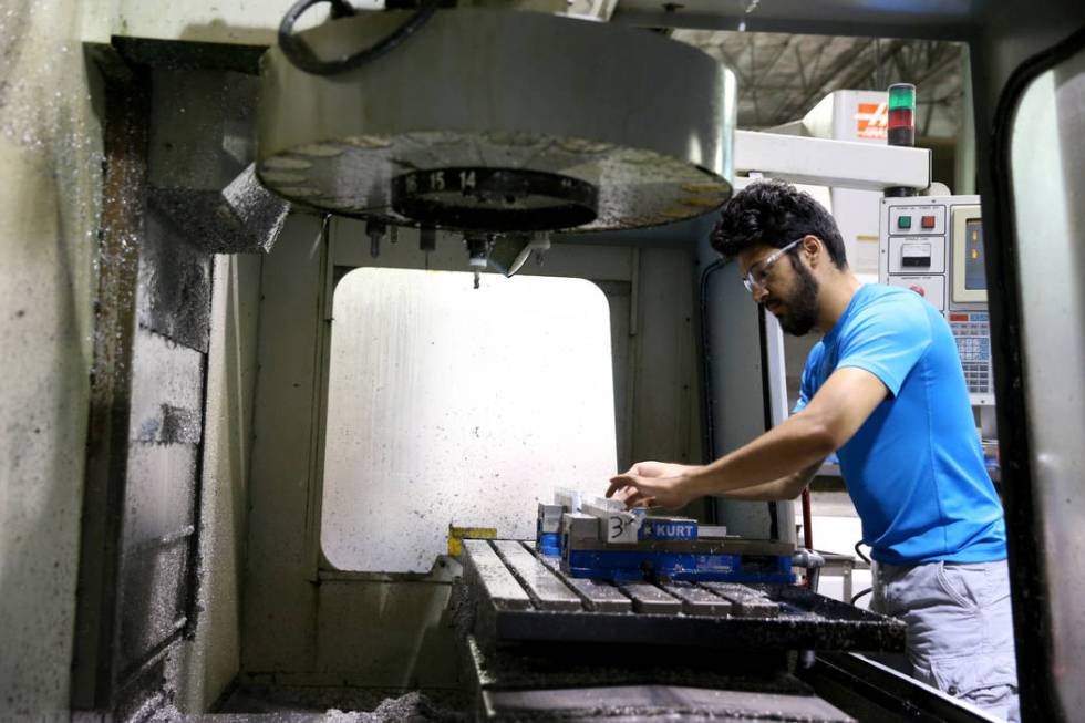 Machinist Alexander Garcia make custom hinges using a computer numerical control (CNC) mill at ...