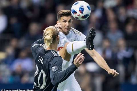 Los Angeles FC's Dejan Jakovic, back, leaps to kick the ball away from Vancouver Whitecaps' Bre ...