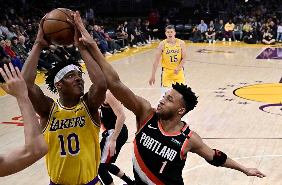 Los Angeles Lakers forward Jemerrio Jones, left, shoots as Portland Trail Blazers guard Evan Tu ...