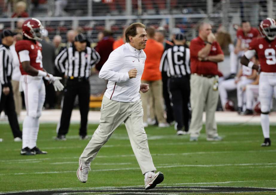 Alabama head coach Nick Saban runs across the field during warm ups before the NCAA college foo ...