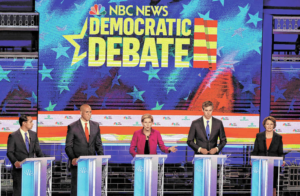 Democratic presidential candidate Sen. Elizabeth Warren, D-Mass., center, answers a question, d ...