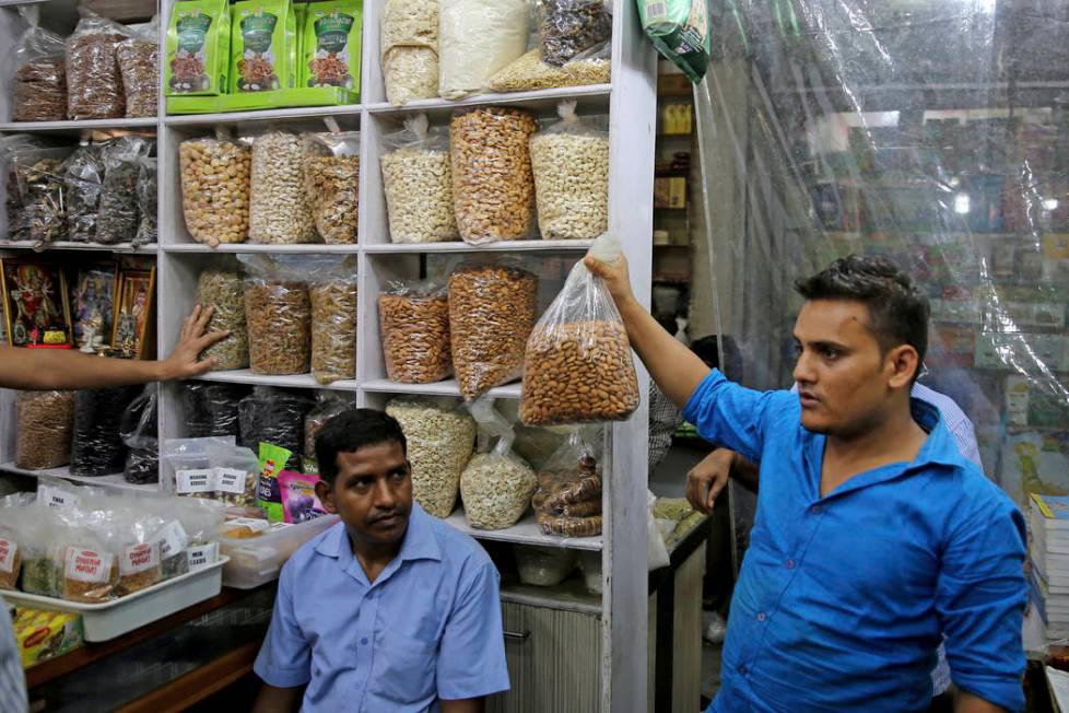 In this Saturday, June 22, 2019 photo, a salesman holds a bag of California almond kernels for ...