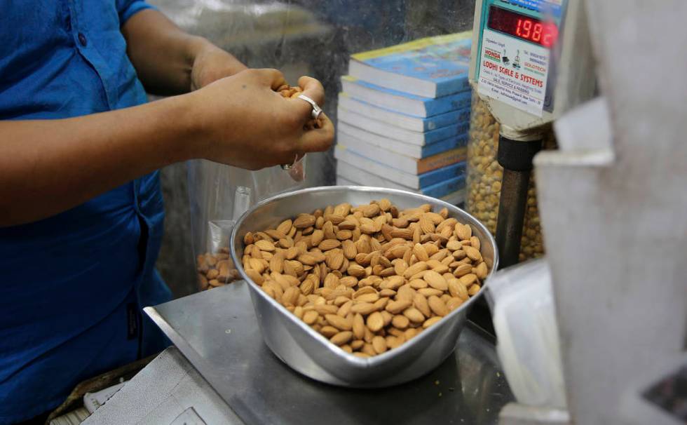 In this Saturday, June 22, 2019 photo, a shopkeeper weighs California almonds for a customer at ...