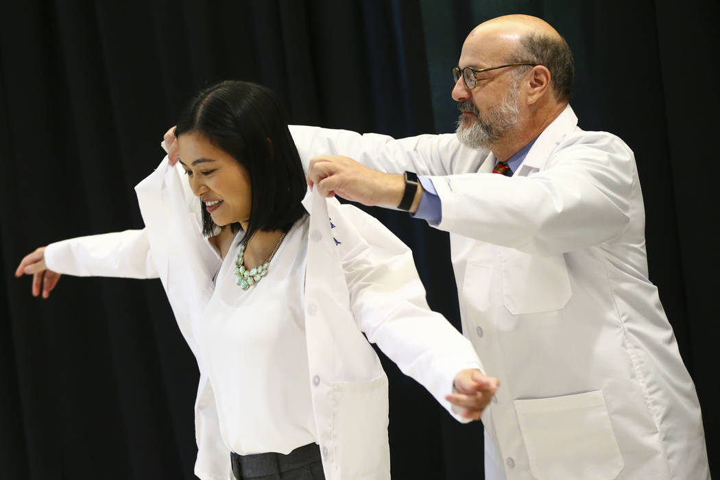 Tom Hunt, family medicine program director at Valley Health System, right, puts a coat onto fam ...