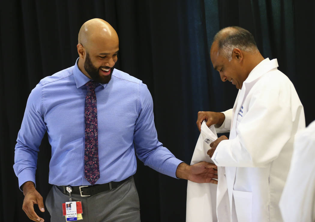 Saju Joseph, general surgery program director at Valley Health System, right, puts a coat onto ...