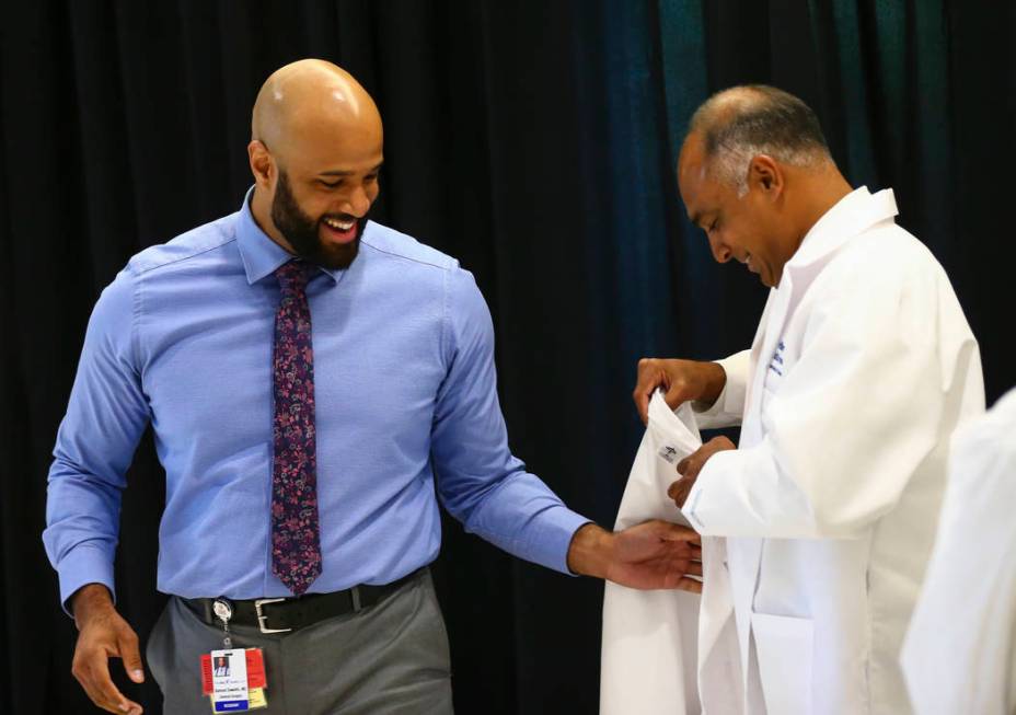 Saju Joseph, general surgery program director at Valley Health System, right, puts a coat onto ...