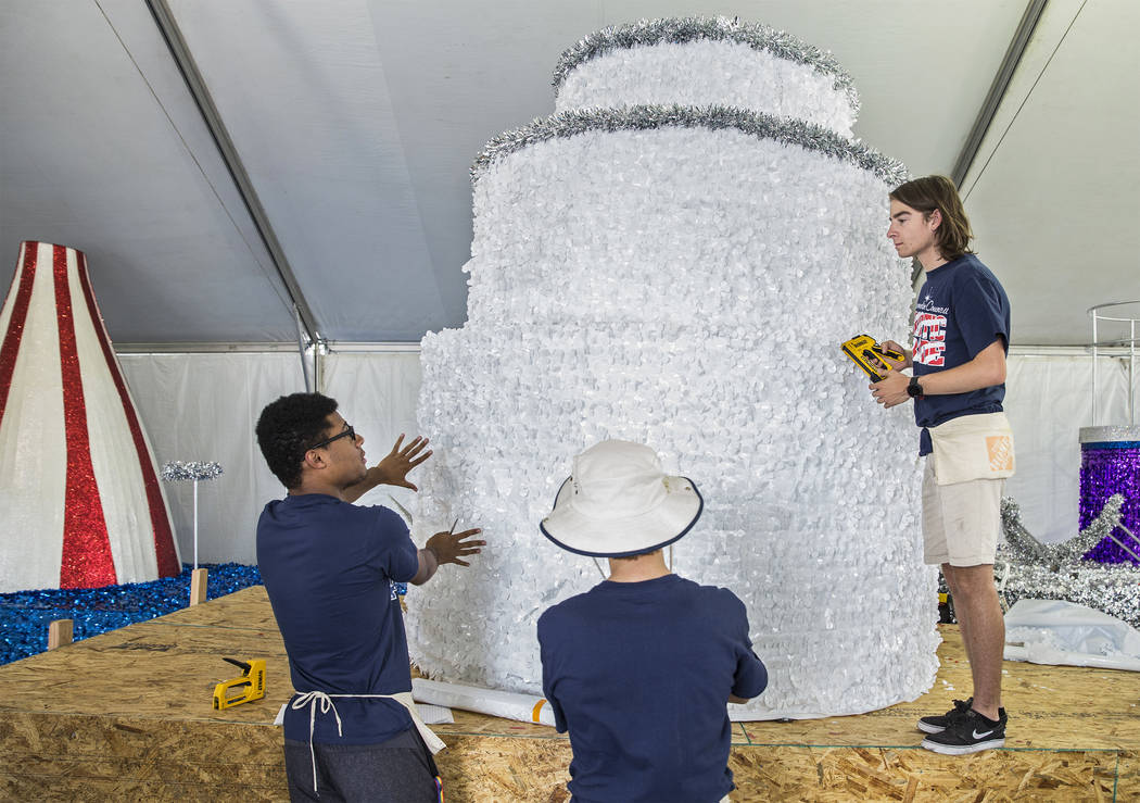 Dwight Jones, left, Connor Jordan and Noah Jordan work on a float during preparation for the Su ...