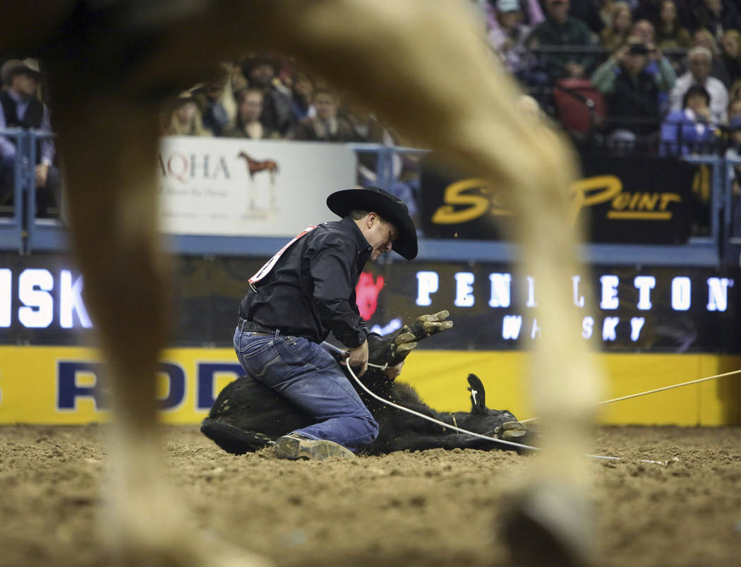 Trevor Brazile of Decatur, Texas (2) competes in tie-down roping during the tenth go-round of t ...