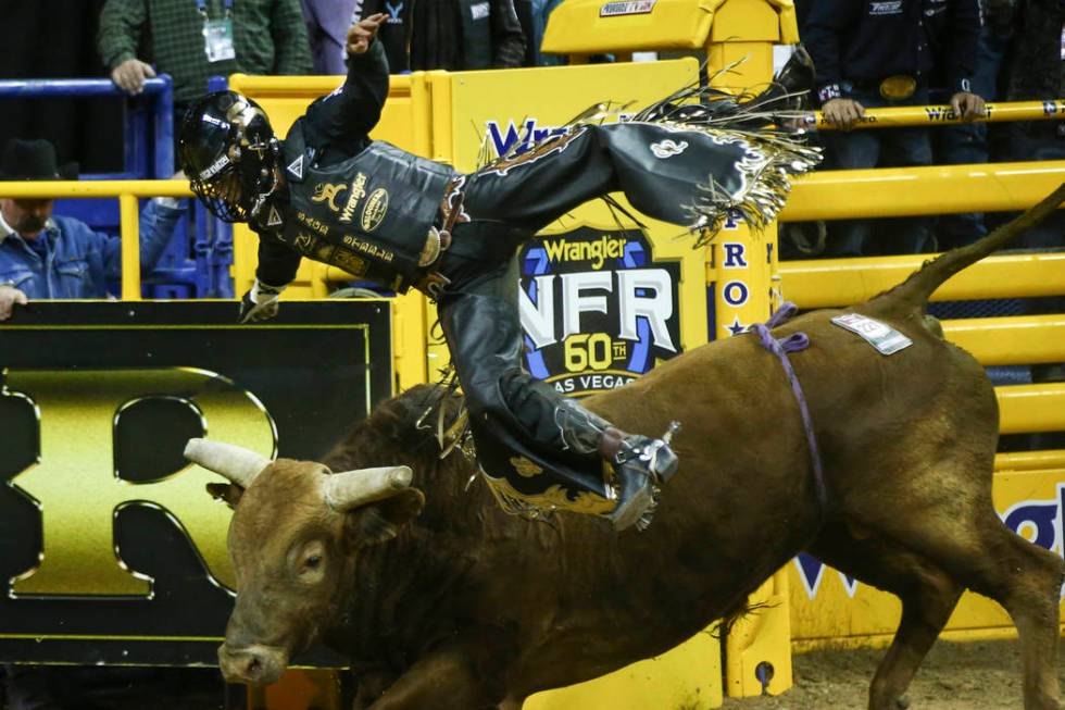 Sage Kimzey of Strong City, Okla. gets upended by "Mortimer" after completing his bul ...