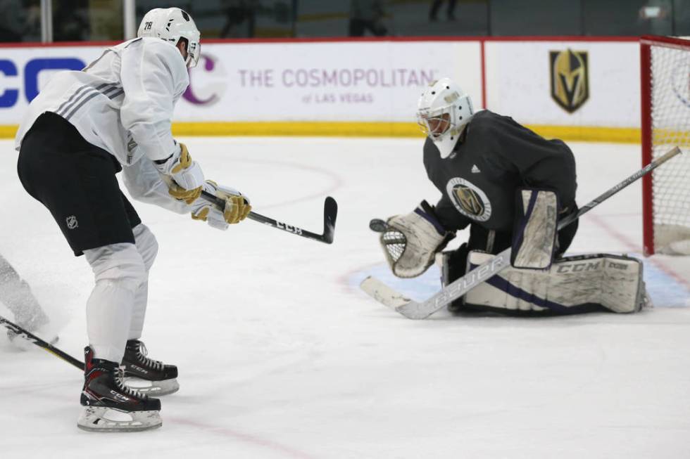 Vegas Golden Knights' Justin Ducharme, left, takes a shot at goaltender Isaiah Saville during a ...