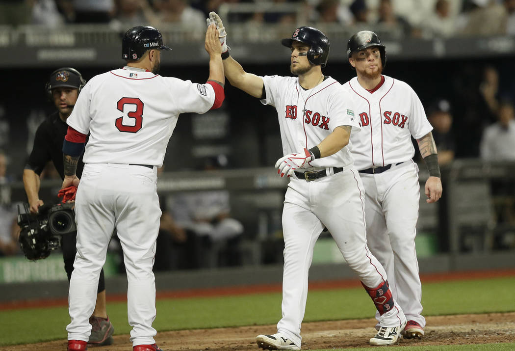 Boston Red Sox's Michael Chavis, center, celebrates his three-run home run with Sandy Leon, lef ...