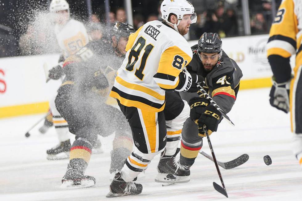 Golden Knights center Pierre-Edouard Bellemare (41) sends the puck past Pittsburgh Penguins rig ...