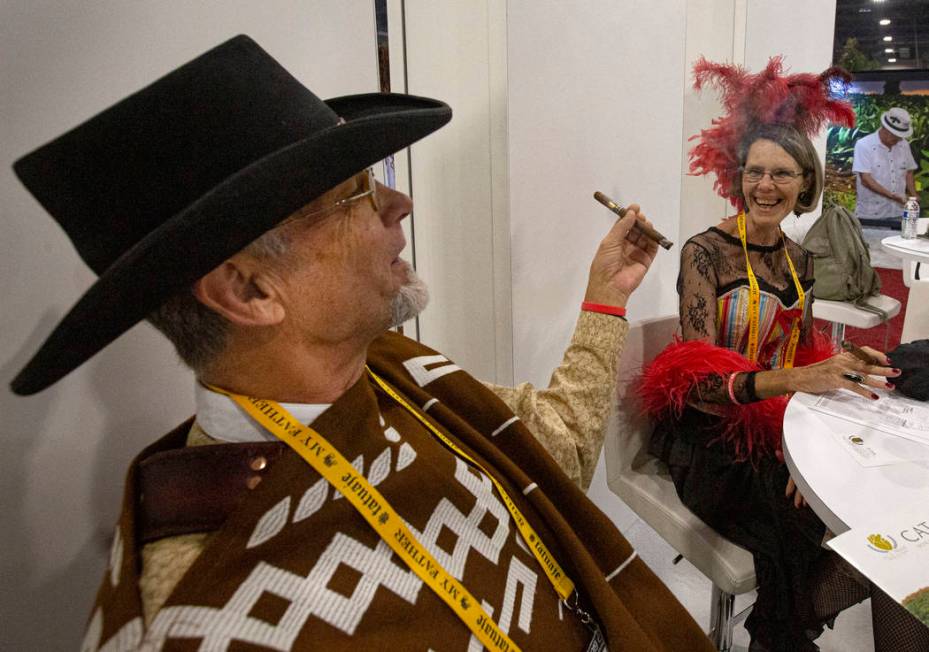 Mick Bieker of Arizona smokes cigar with his partner Suzanne Wilson, owner of Smoke Signals in ...